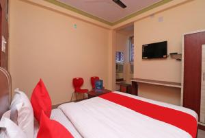 a bedroom with a bed and a tv on the wall at Hotel Padoshi Puri Near Sea Beach & Temple - Parking Facilities - Best Hotel in Puri in Puri