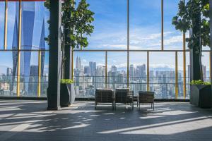 uma mesa e cadeiras num edifício com vista para a cidade em Opus Residences by Opus Hospitality em Kuala Lumpur