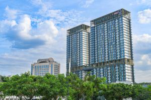 two tall buildings in a city with trees in front at Opus Residences by Opus Hospitality in Kuala Lumpur