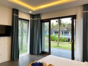 una camera con un letto e una grande finestra di Starlight Villa Beach Resort & Spa a Phan Thiet