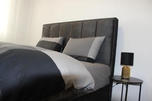 a bedroom with a black and white bed with pillows at Apartment M in Smederevo