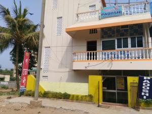 a building with a balcony on the side of it at Hotel Padoshi Puri Near Sea Beach & Temple - Parking Facilities - Best Hotel in Puri in Puri
