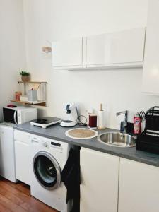 a kitchen with a washing machine and a sink at L'anjou - St Nazaire - Comme à la maison in Saint-Nazaire