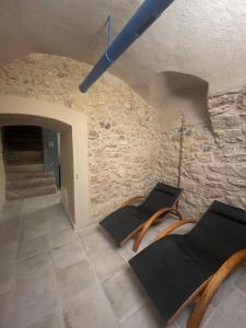 Habitación con 2 sillas y pared de piedra. en Arqué Apartments - Arco Centro, en Arco