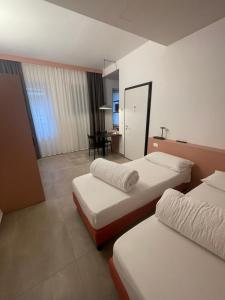 ein Hotelzimmer mit 2 Betten und einem Tisch in der Unterkunft Arqué Apartments - Arco Centro in Arco