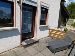 una silla en un patio fuera de una casa en FeWo Kailbachtal, en Landscheid