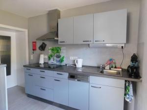 a kitchen with white cabinets and a sink at FeWo Kailbachtal in Landscheid