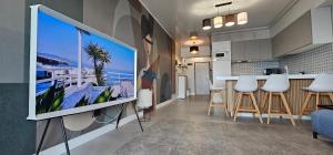 uma sala de estar com uma televisão pendurada numa parede em SunSet Lake Boutique Apartment em Mamaia