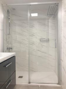 La salle de bains est pourvue d'une douche avec une porte en verre. dans l'établissement Luxury Beach Suite by Canary365, à Las Palmas de Gran Canaria