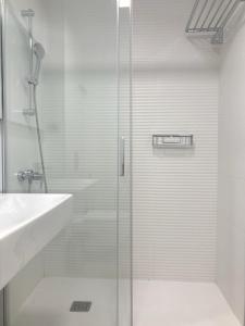 a shower with a glass door next to a sink at Luxury Beach Suite by Canary365 in Las Palmas de Gran Canaria