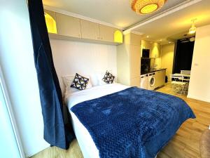 een slaapkamer met een bed met een blauwe deken bij Parisien Hôtel style in Pré Saint Gervais