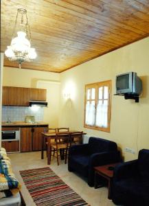 a living room with a couch and a tv and a table at Epavli Antonis in Konitsa