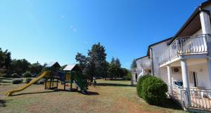 a playground in front of a house with a slide at Ai Pini Medulin Resort in Medulin