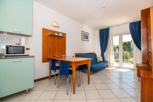 a kitchen and dining room with a table and chairs at Ai Pini Medulin Resort in Medulin