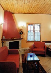 a living room with red furniture and a fireplace at Epavli Antonis in Konitsa
