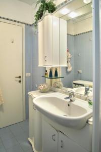 a bathroom with a white sink and a mirror at Condominio Maria Ida in Caorle +19 photos