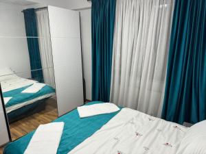 a bedroom with two beds and a mirror at Apartament Central, Năsăud in Năsăud