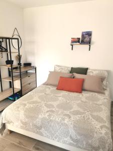 a bedroom with a bed with a red pillow on it at Appartement Jardin et Piscine Les anges du maquis location Corse-du-Sud in Conca +25 photos