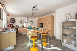 a kitchen with yellow stools and a wooden counter top at Maison Rioma - Grande maison à 200m de la plage in Plounéour-Trez