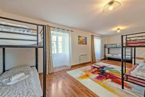 a room with three bunk beds and a rug at Maison Rioma - Grande maison à 200m de la plage in Plounéour-Trez