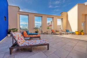 a patio with couches and chairs and windows at Maison Rioma - Grande maison à 200m de la plage in Plounéour-Trez