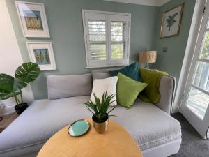 uma sala de estar com um sofá e uma mesa em Town Centre Garden Retreat em Cheltenham