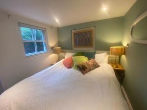 a bedroom with a large white bed with pillows at Town Centre Garden Retreat in Cheltenham