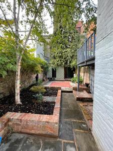 um jardim com um passadiço de tijolos ao lado de um edifício em Town Centre Garden Retreat em Cheltenham