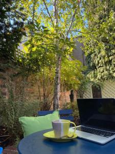 a laptop sitting on a table with a cup of coffee at Town Centre Garden Retreat in Cheltenham
