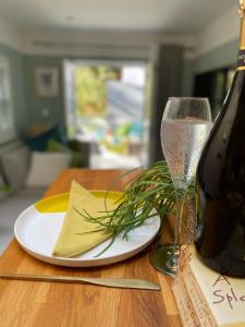 a table with a plate and a glass of wine at Town Centre Garden Retreat in Cheltenham