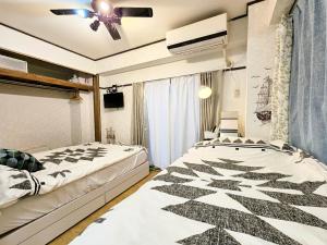 um quarto com 2 camas e uma ventoinha de tecto em Downtown Tokyo/Taito-gu/2min walk nearest sta/Ueno/Wi-Fi/302 em Tóquio