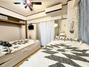 a bedroom with two beds and a ceiling fan at Downtown Tokyo/Taito-gu/2min walk nearest sta/Ueno/Wi-Fi/302 in Tokyo