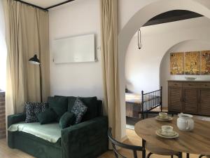 a living room with a green couch and a table at Loft pod Starym Kasztanem in Krynica Zdrój