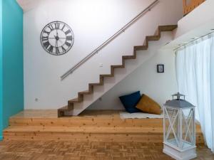 un escalier dans une maison avec une horloge sur le mur dans l'établissement Le cinéaste - Parking coeur de ville, à Montpellier