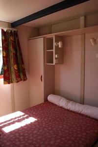 Habitación pequeña con cama y ventana en Camping Via Romana, en Prunelli-di-Fiumorbo