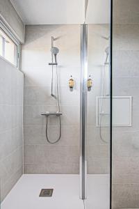 La salle de bains est pourvue d'une douche avec une porte en verre. dans l'établissement Hotel Centre Plage, à Argelès-sur-Mer