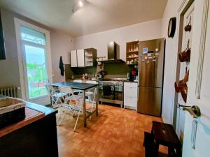 uma cozinha com uma mesa e um frigorífico em Home - Champoulains - Séjour à Auxerre em Auxerre