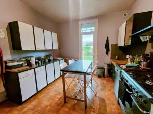 uma cozinha com armários brancos e uma mesa em Home - Champoulains - Séjour à Auxerre em Auxerre