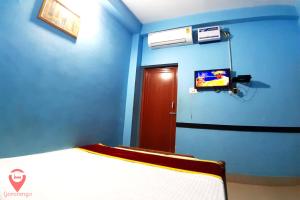 a blue room with a bed and a tv at Hotel Star Lodge Puri in Puri