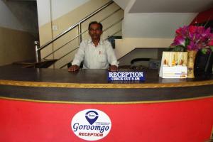 a man standing behind a counter with a red and black at Hotel Star Lodge Puri in Puri