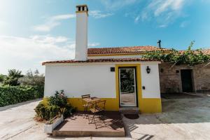 a small yellow and white building with a lighthouse at Quinta de S. Miguel 'Casa Das Oliveiras in Fundão