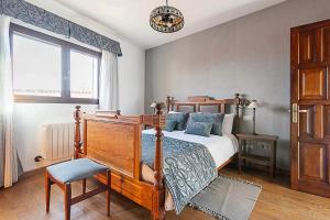 a bedroom with a bed and a chair and a window at Casa típica canaria en el Parque Rural de Doramas in Teror