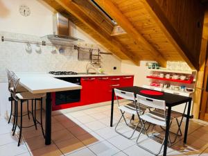 a kitchen with red cabinets and a table and chairs at La casa di Vale in Arona