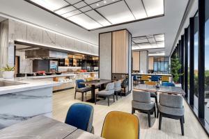 an open kitchen and dining room with tables and chairs at Hyatt Place Makassar in Makassar