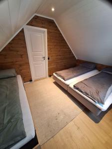 een zolderkamer met 2 bedden en een deur bij Mini Lyngen in Jægervatnet