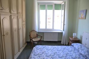 um quarto com uma cama, uma janela e uma cadeira em Casa Gegè Lingotto em Turim