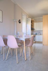 uma mesa de jantar com cadeiras cor-de-rosa numa cozinha em Casa Gegè Lingotto em Turim