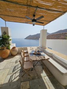 a patio with a table and chairs and the ocean at The Anchor House in Symi