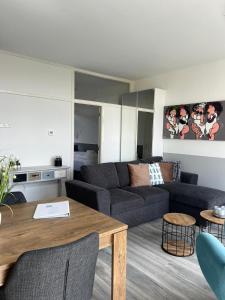 una sala de estar con un sofá y una mesa en Dutch Line, De Schelp, Gratis parkeren, en Zandvoort