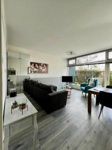una sala de estar con un sofá y una mesa en Dutch Line, De Schelp, Gratis parkeren, en Zandvoort